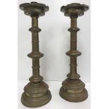 A large pair of brass ecclesiastical style altar type candlesticks with castellated drip trays on
