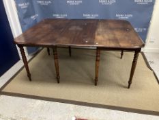 An early 19th Century mahogany rounded rectangular extending dining table on slender turned and