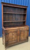 An 18th Century oak dresser, the two tier boarded plate rack with moulded cornice and three rows