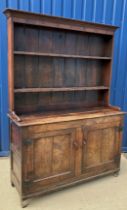 An 18th Century oak dresser, the two tier boarded plate rack with moulded cornice and three rows