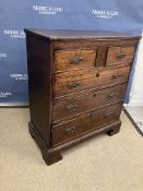 A 19th Century Provincial oak chest of two short over three long drawers with ornate brass drop