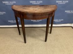 An early 19th Century mahogany and cross-banded demi-lune fold-over card table on square tapered
