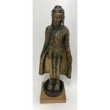 A 19th Century Tibetan carved giltwood figure of the Buddha in long jacket, his hands at his