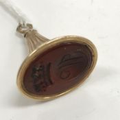 A William IV yellow metal seal of fluted horn form, the oval carnelian inscribed with a ''W'' within