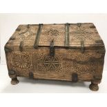 A vintage Indian Mughal dowry chest with carved medallion and brass bound decoration, raised on