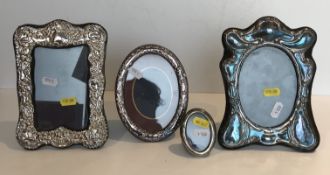 A collection of four various silver mounted photograph frames including one with embossed foliate