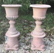 A pair of composite stone terracotta style Victorian style garden urns on stands 106 cm high