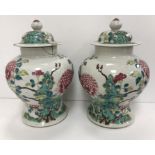 A pair of 19th Century Chinese famille rose vases and covers, the main body decorated with