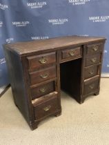 A Victorian stained pine and beech framed kneehole desk, the writing surface over a central slim