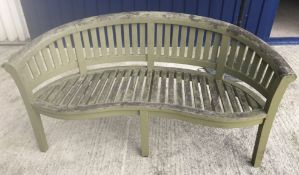 A slatted garden bench of bow back form