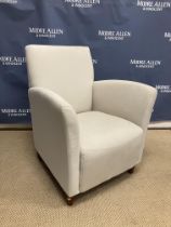 A modern upholstered armchair on turned