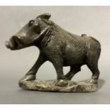 A stone sculpture of a wart hog on naturalistic base, 21cm wide x 16.5cm