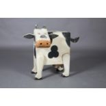 A black and white cow shaped chest with single drawer, the tail for a handle, 83cm wide x 46cm