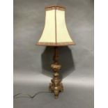 A gilt and red baroque style table lamp on three paw feet, 63cm high to fitting