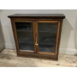 A rosewood and glazed two door bookcase on plinth base, 96cm wide x 92cn high x 31cm