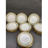 A set of 24 Minton dinner plates bordered in gilt and pale green and with the initial A within an