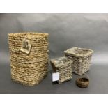 A rush woven basket of tall square outline together with two pale grey wicker baskets, graduated