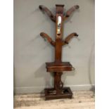 A mid Victorian mahogany hat and coat stand, the column inset with a mirror, above a glove box and