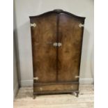 A walnut gentleman's wardrobe of arch profile with two doors, the interior fitted with shelves and