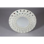 A modern silver-finish circular wall mirror, the frame pierced with three rows of graduated tear