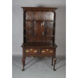 An oak dresser and rack of small proportions, having a moulded cornice and scalloped frieze above