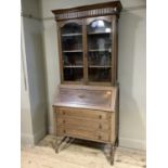 A 1920s oak bureau bookcase having two glazed doors over fall front and three drawers below, on