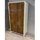 A rosewood effect and cream gents wardrobe by Dillon with compartments and slides