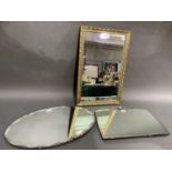 An oval bevelled wall mirror, a 1930s bevelled wall mirror with silver plated cresting and a more