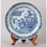 A Chinese blue and white saucer dish painted with pagoda, pine tree and willow tree in a river and