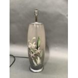 A pale grey glass table lamp internally printed with orchids, chrome fittings, with shade, 47.5cm to