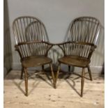 A pair of reproduction high back Windsors, rail backs, saddle seats, turned legs joined by a