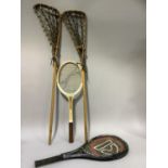A pair of lacrosse sticks and two tennis rackets