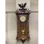A 19th century walnut wall clock having a eagle finial to the pediment, split turned pilasters to