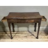 A George II mahogany fold over tea table of serpentine outline having a fold over top and drawer