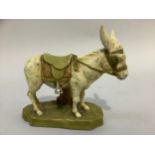 A Royal Dux Bohemia figure of a donkey wearing a saddle, on naturalistic base, pink triangular pad