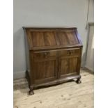 A 1920s mahogany bureau having gadroon carved edges, twin indented panel fall front, fitted interior