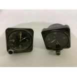 Two military dashboard clocks, the first with luminous white Arabic numerals, the dial stamped 8