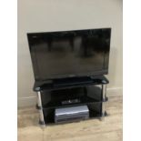 A Sony Bravia television with glass stand, Alba DVD player and VHS player
