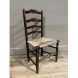 A 19th century elm rush seated ladder back chair