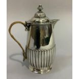 A Victorian silver hot water jug, reeded base and lid with acorn finial and wicker covered handle,