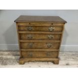 A reproduction dwarf walnut crossbanded chest, having a pull out slide and four graduated drawers,
