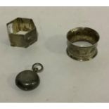 Two silver napkin rings, hexagonal, of engine turned decoration, initialled, palmette bands with