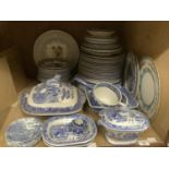 A quantity of willow pattern dinner ware including plates in various sizes, sauce tureens, ladel,