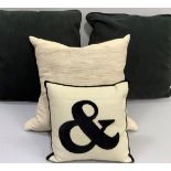 Two large black cushions, one medium beige cushion and a small beige and black cushion with