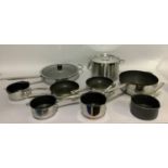 A selection of stainless steel pans including a large stock pan, wok, frying pan, sauce pans,