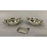 A pair of Edward VII silver mustard pots each with a silver spoon of oval outline with a beaded rim,