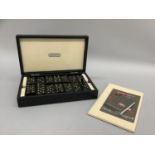 An Italian set of black and diamante set dominoes contained in a black leather and cream suede