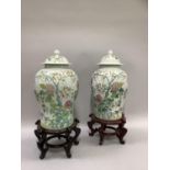 A pair of Chines temple vases of baluster form, the domed covers with knopped finials, printed and