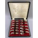 A cased set of six silver plated and faux horn handled steak knives and forks