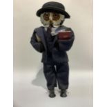 A figure of an owl wearing a bowler hat and suit, 47cm high